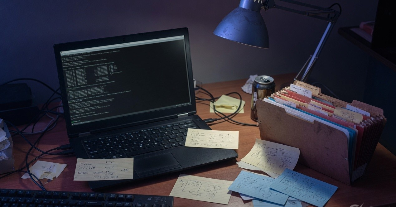 Dark terminal on a laptop beside accordion folders suggesting a hidden filesystem