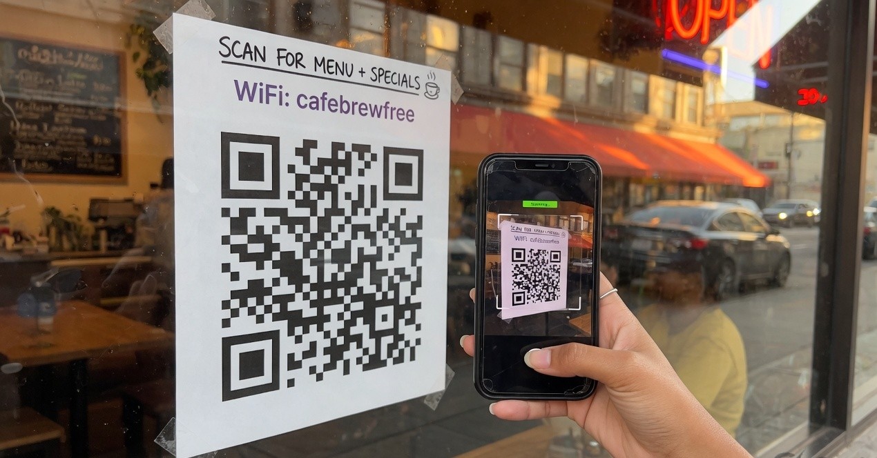 Smartphone scanning a QR code sticker on a cafe window